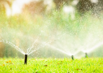 sprinklers running in a green yard, francoach logo is in the corner due to new franchise owner for conserva irrigation
